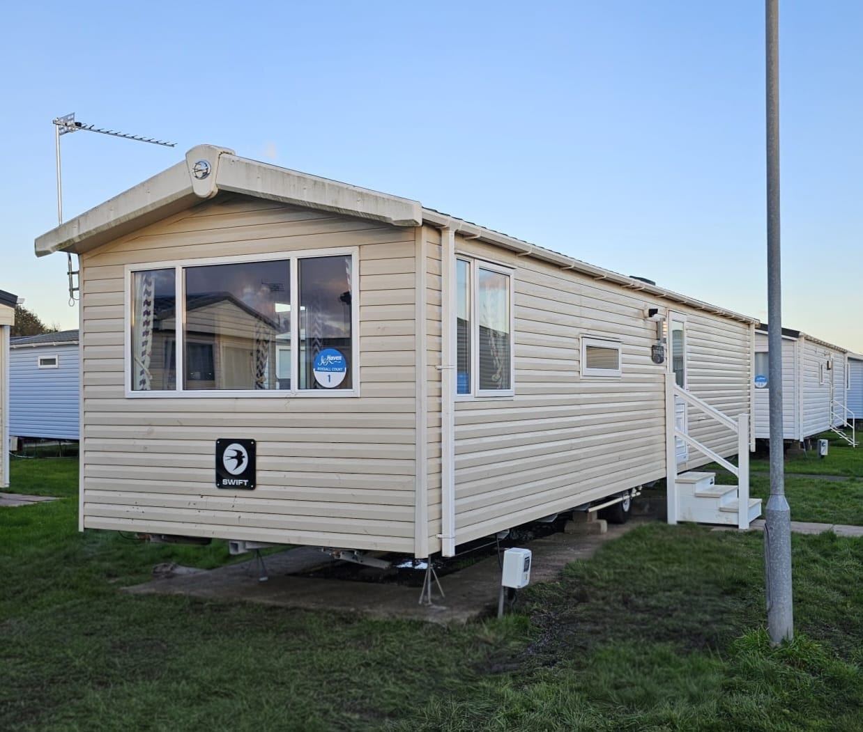 Rossall Court caravan exterior — Swift Trading Post with Haven sign