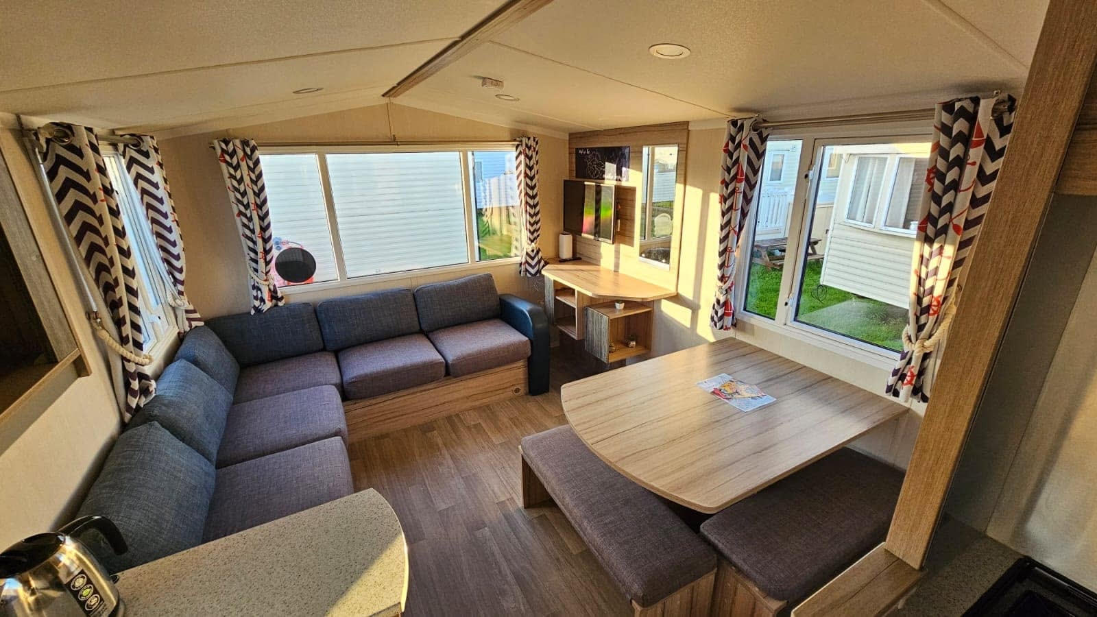 Rossall Court wide lounge with grey corner sofa and dining table